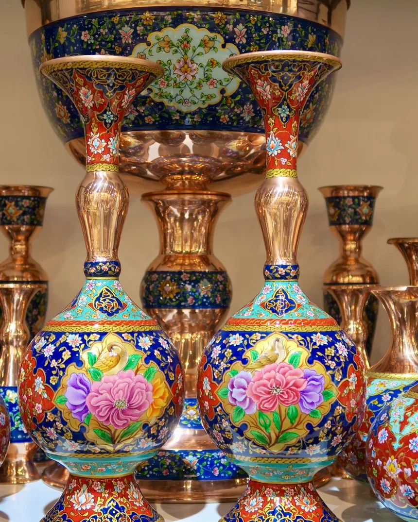 Jarrones de cobre esmaltado con motivos florales en azul, rojo y turquesa sobre metal pulido